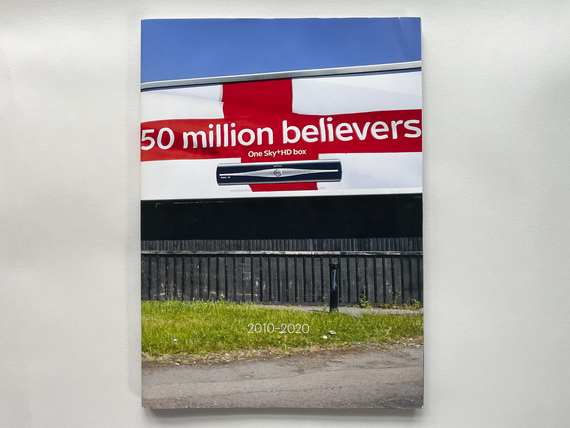 cover of the book is a photograph of a Sky TV roadside advert with the words 50 Million Believers, above the hoarding is a blue sky, below are the words 2010-20