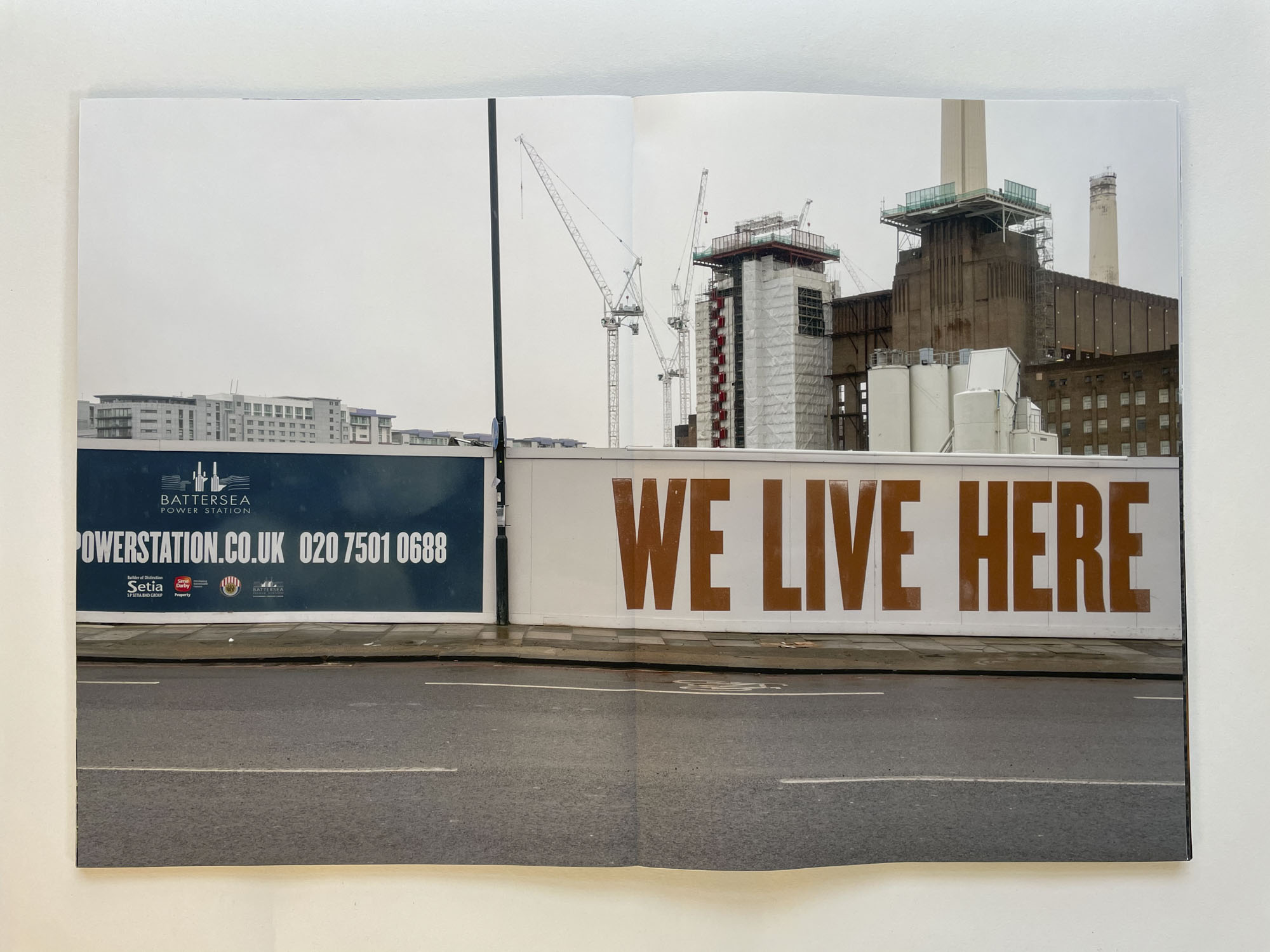 a hoarding with the words Battersea Power Station WE LIVE HERE