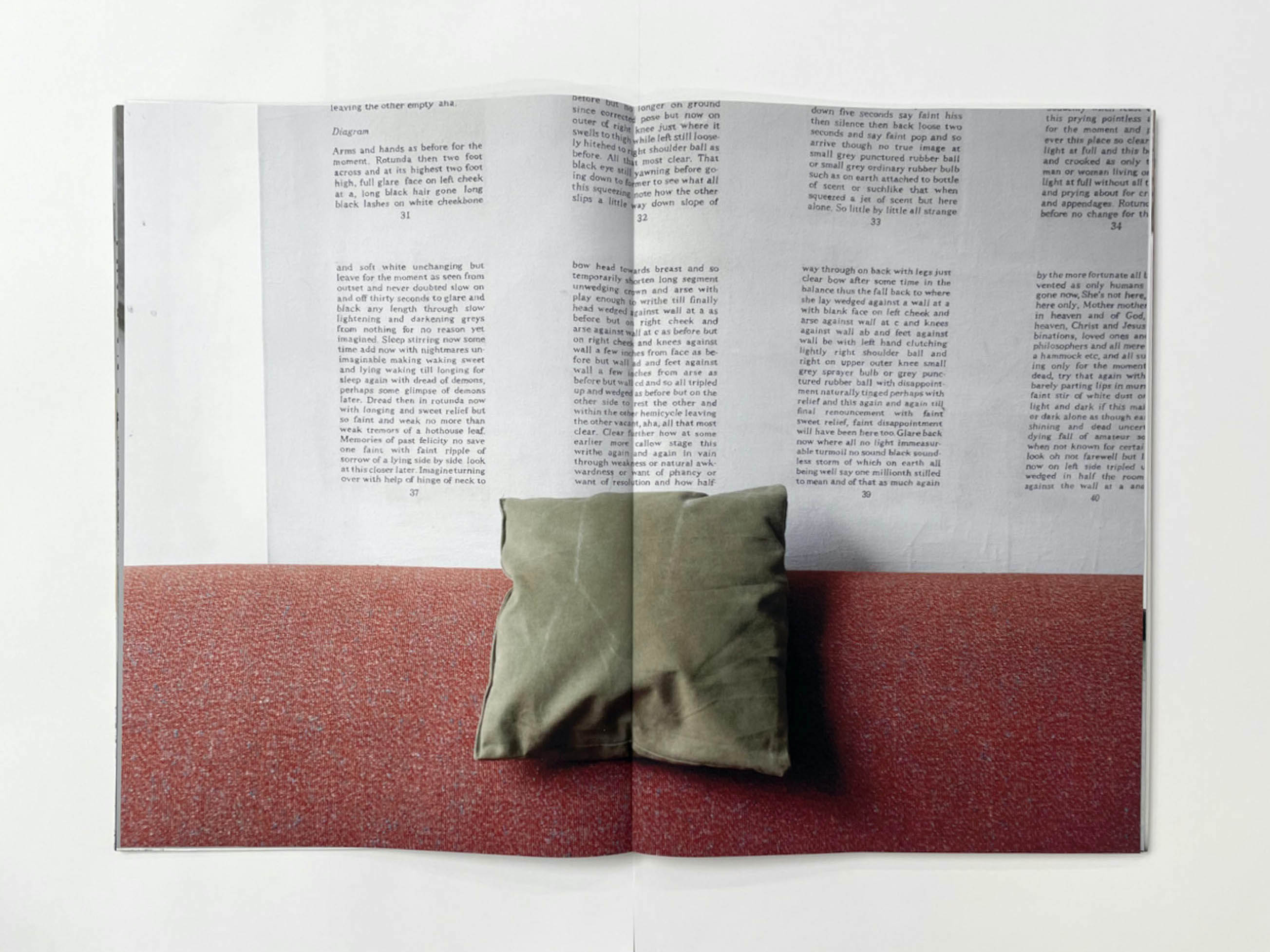 a green cushion sits on the back of an orange sofa, on the wall behind is a poster with paragraphs of black numbered text