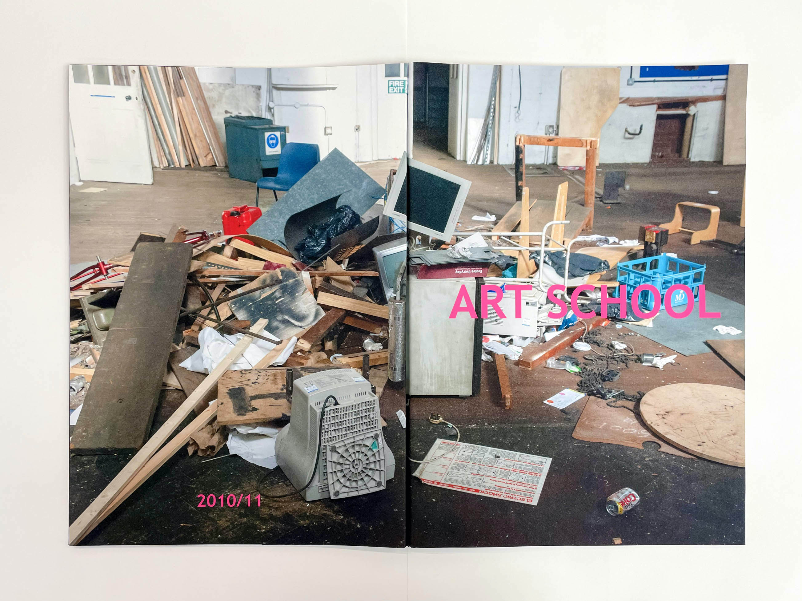 the whole cover of the book opened out, showing detritus in a large room, in smaller pink letters it says 2010/11 and large letters Art School