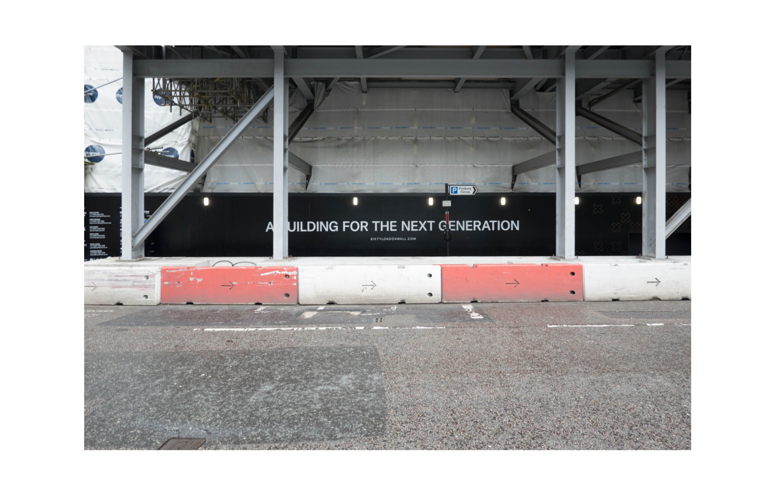 a hoarding below scaffolding says A building for the next generation