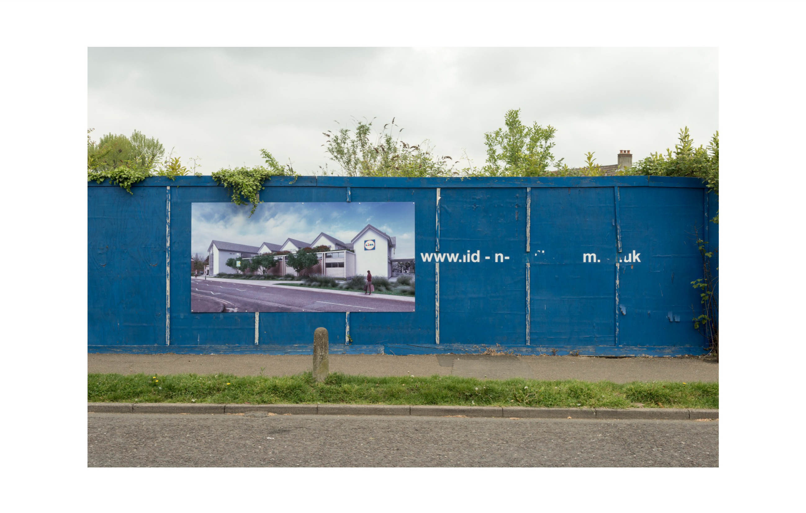 a blue hoarding show an architects impression of a new Lidl supermarket, next to the picture is a weathered and indecipherable website address