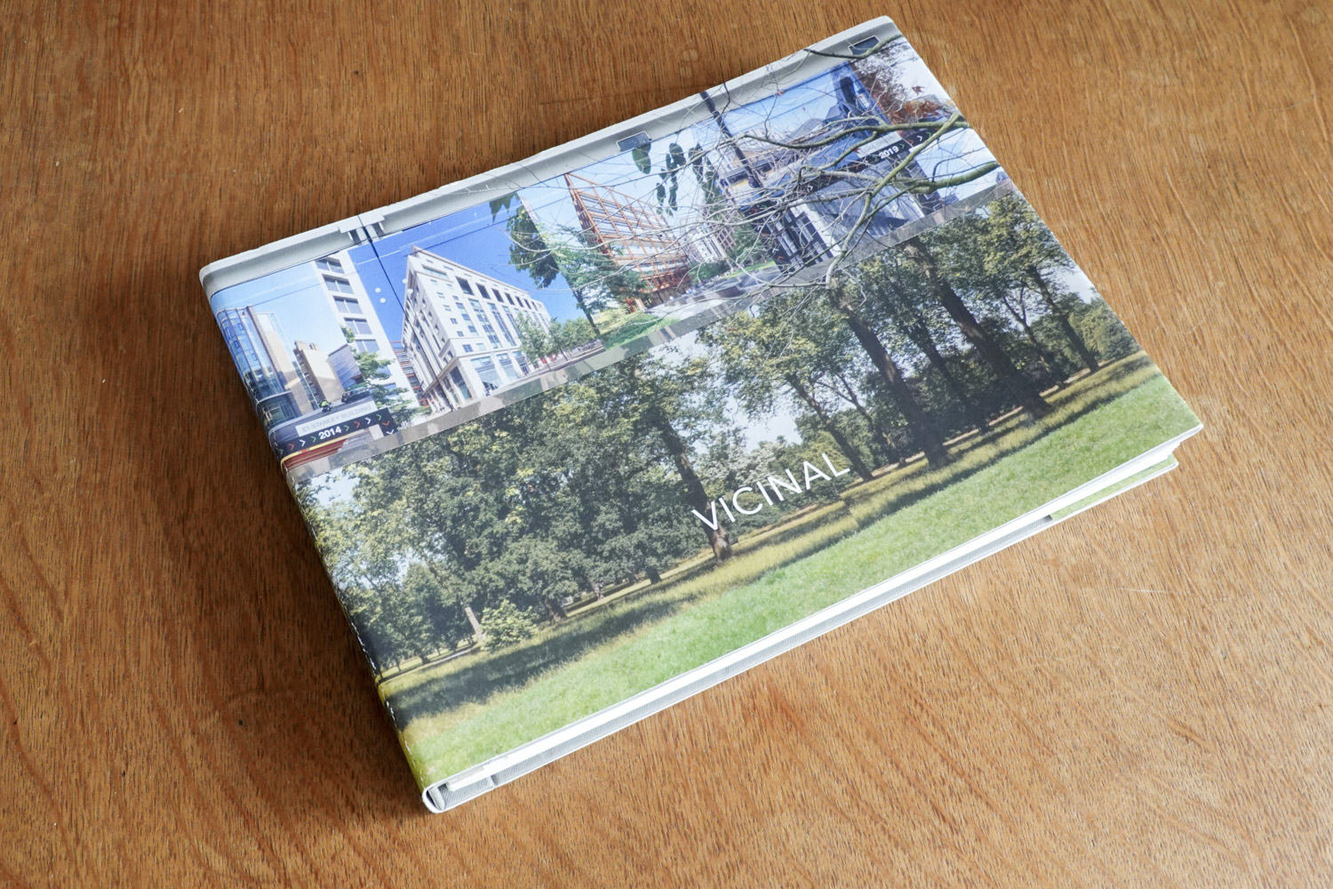 the cover of the book has a photo of a hoarding on which can be seen trees and pictures of new buildings