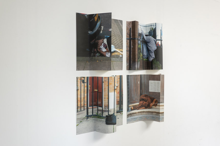 an oblique view from the left of the grid of the four images pinned to the white wall