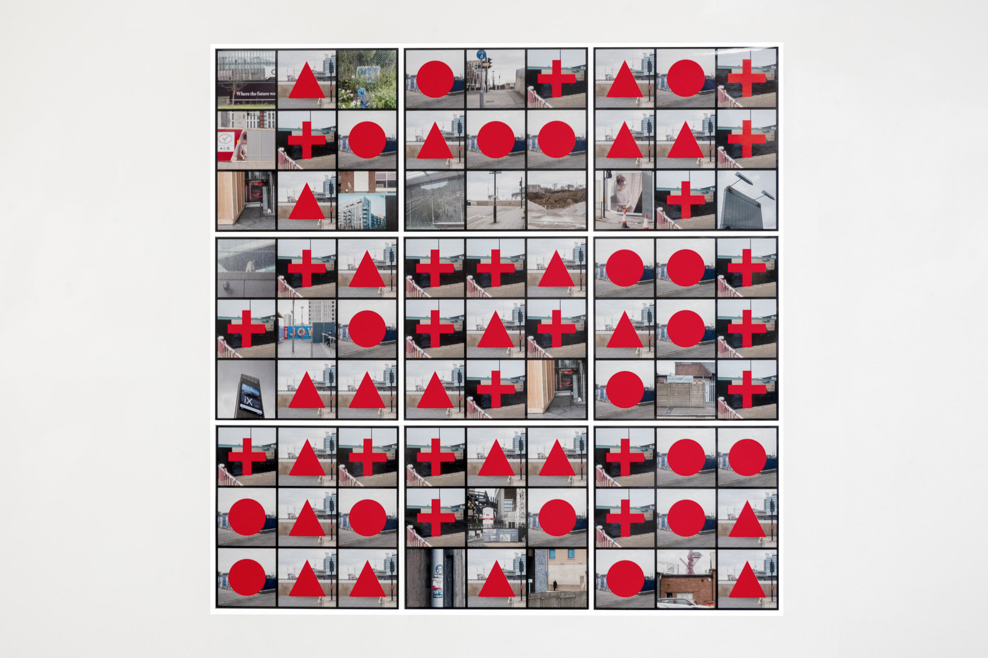 9 photographic prints in a grid on a wall with red text at the centre of each image