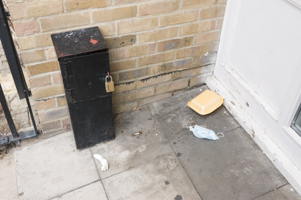 a pair of cheap silver high heeled shoes lie discarded in the doorway