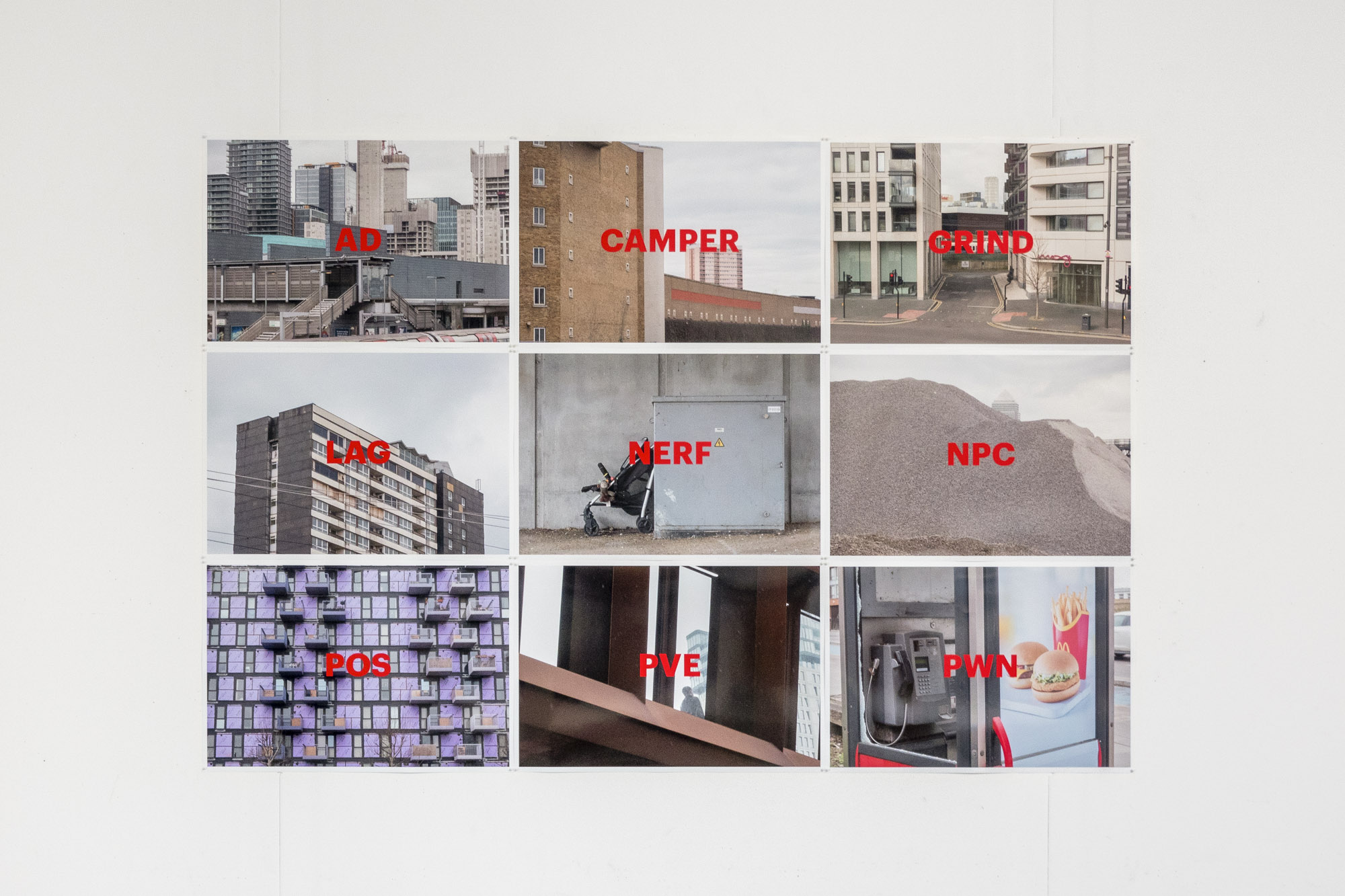9 photographic prints in a grid on a wall with red text at the centre of each image